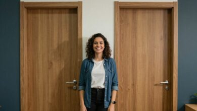 Pessoa confiante sorrindo diante de várias portas coloridas, representando novas oportunidades de recolocação profissional.