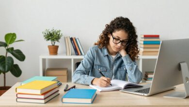 Pessoa estudando inglês com livros e computador, cercada de materiais coloridos e uma atmosfera inspiradora.