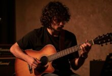 Um músico apaixonado tocando guitarra em um palco com iluminação dramática, simbolizando o sonho e a dedicação da carreira musical.