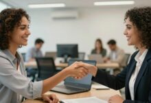 Uma pessoa profissional e sorridente apertando a mão de um recrutador em um escritório moderno, transmitindo confiança e sucesso em uma entrevista de emprego.