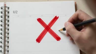 Uma pessoa marcando um calendário com um 'X' vermelho, simbolizando a consistência e a disciplina diária alcançada.
